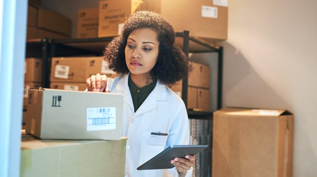 Pharmacy delivery driver loading orders into a delivery truck.